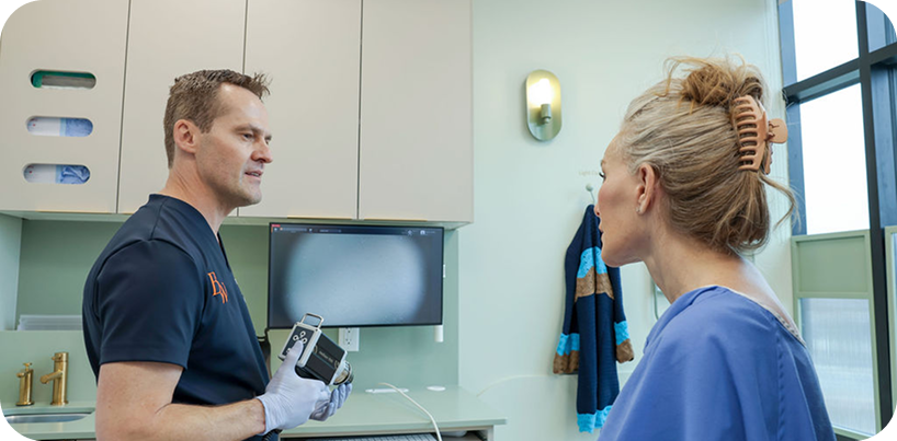 Two clinic team members discussing imaging equipment.