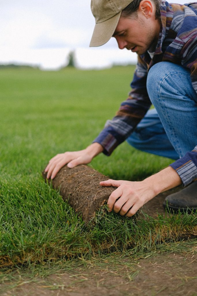 a farmer in a plaid shirt, jeans and baseball cap laying down turf, highlighting occupations with high skin cancer risk